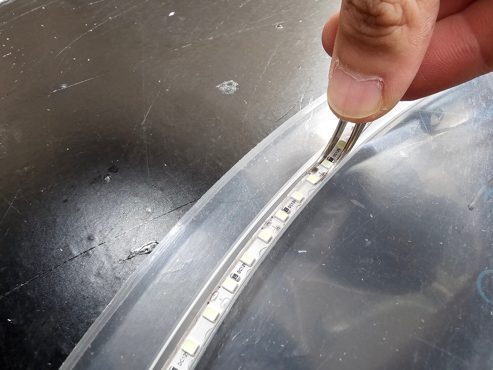 アクリルの溝に沿ってLEDネオンを配置する様子